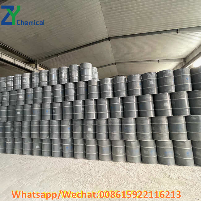 Massive inventory of calcium carbide stored securely in standardized steel drums inside a large-scale industrial warehouse.