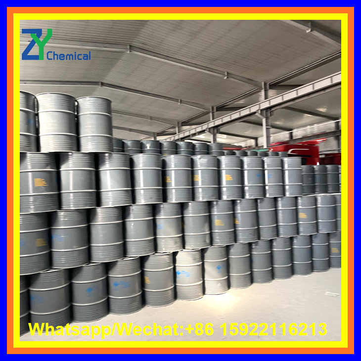 Hundreds of grey metal drums filled with calcium carbide powder are stacked neatly inside a large warehouse facility.
