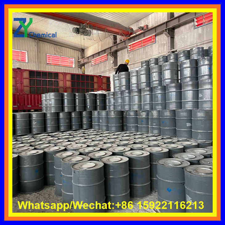 A worker oversees a massive inventory of calcium carbide powder stored in tightly sealed steel drums ready for shipment.