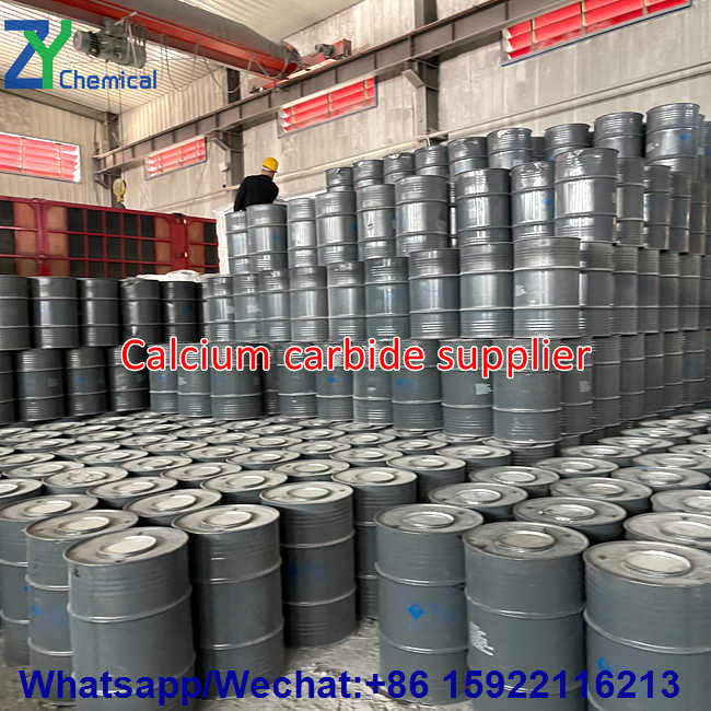 At the storage and logistics site of an industrial-grade calcium carbide supplier, personnel conduct pre-shipment inspections and prepare for loading and unloading within a densely packed storage area for calcium carbide drums.